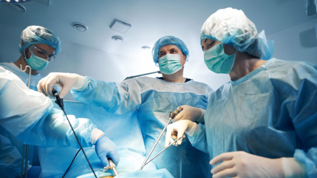 Especialista em cirurgia com instrumentos laparoscópicos durante a operação do paciente