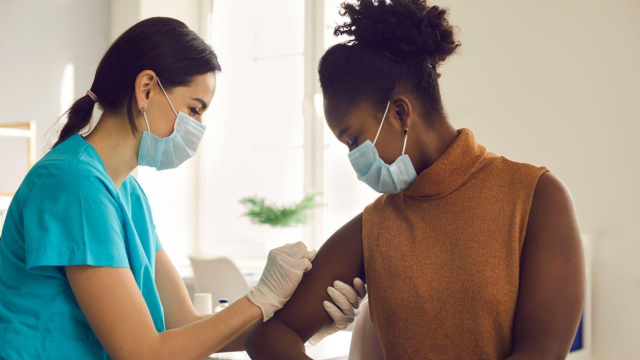mulher negra sendo vacinada para gripe por médica