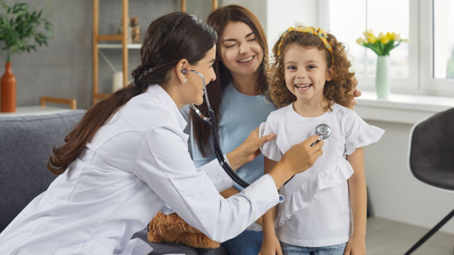 médica consultando menina criança ao lado da mãe