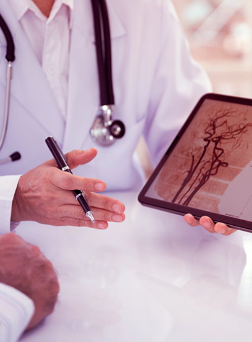 médico sorridente, com estetoscópio no ombro e braços cruzados.
