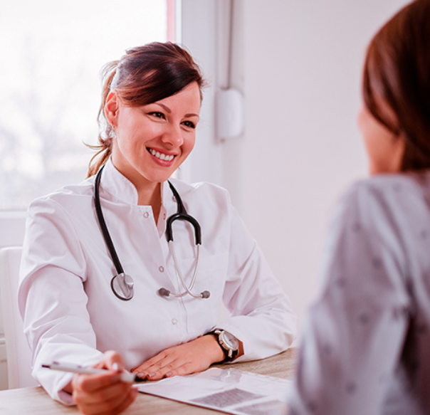 médica sorridente, com estetoscópio no ombro, em consulta com paciente