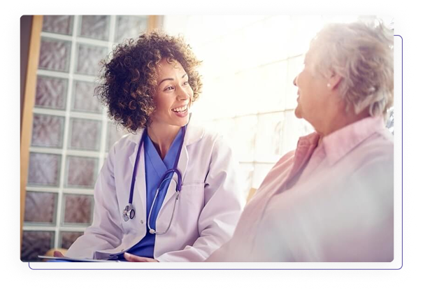 Médica conversando amigavelmente com paciente idosa