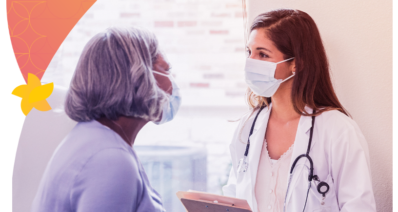Imagem de uma médica conversando com uma paciente ambas de máscara