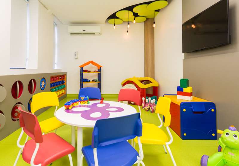 Brinquedoteca do Hospital BP, com mesa, cadeiras e diversos brinquedos coloridos à disposição dos clientes pediátricos.
