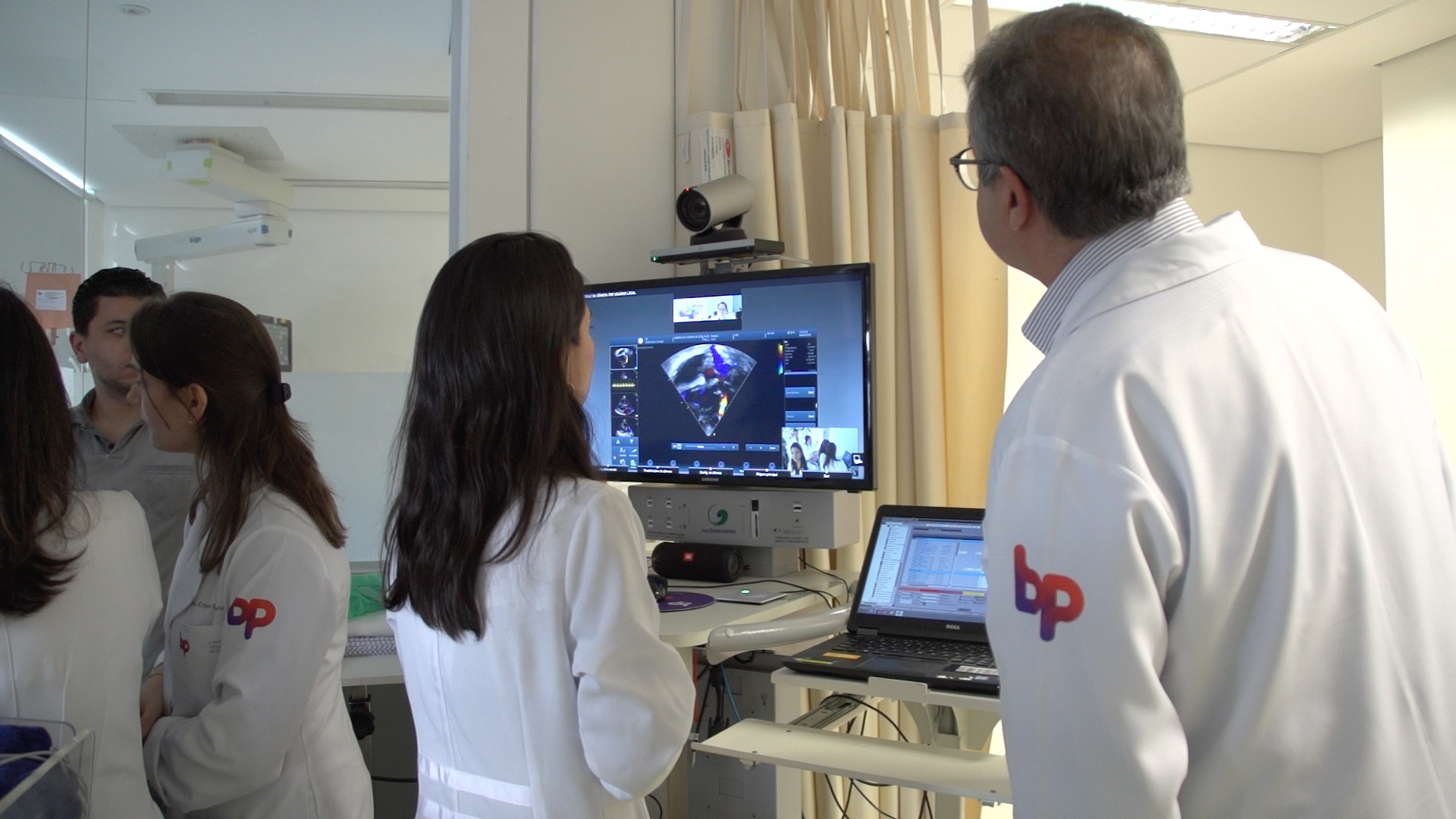 Doutora Juliana Pacheco fala com os especialistas de Pittsburgh por meio de sistema de videoconferência, que mostra na tela o resultado do ecocardiograma do paciente.