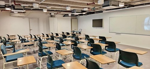 Sala de aula vazia, com carteiras e lousa