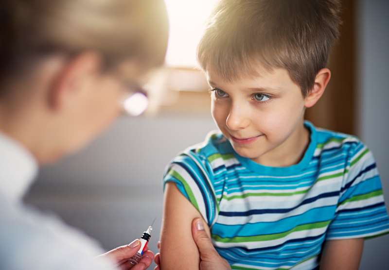 Criança recebendo dose de vacina.