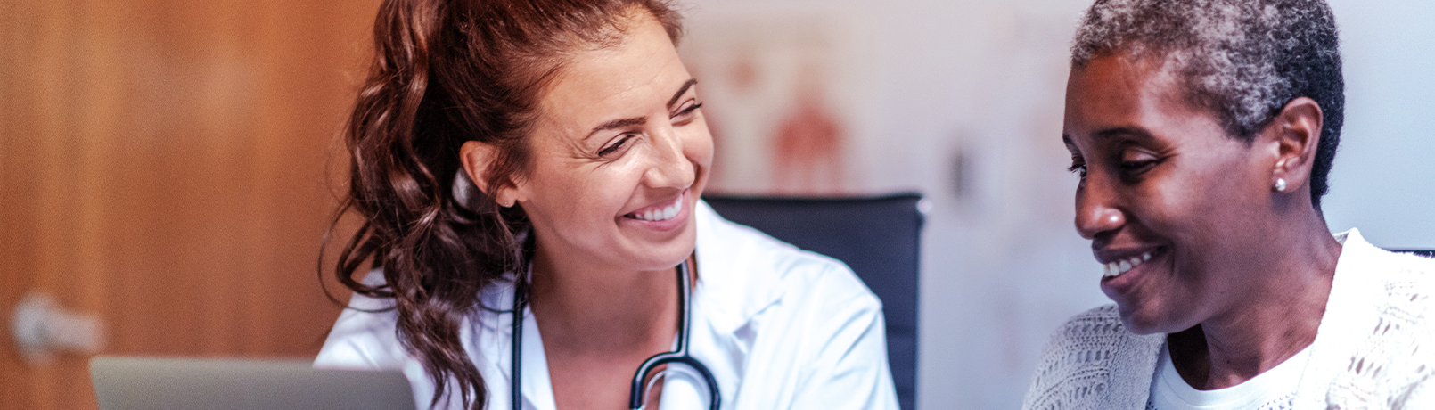 Imagem de uma médica e de uma paciente sorrindo.