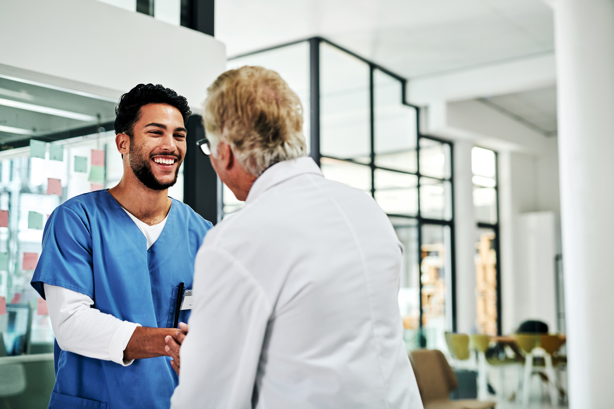 Imagem de um enfermeiro e de um médico sorrindo